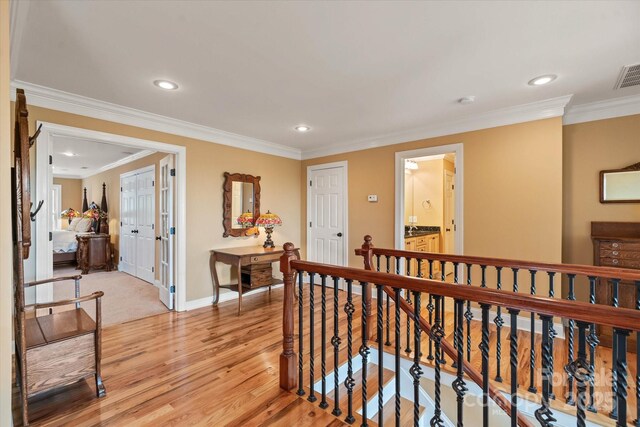 hallway featuring an upstairs landing, baseboards, recessed lighting, light wood finished floors, and ornamental molding