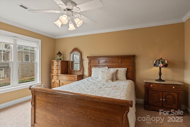 carpeted bedroom with baseboards, crown molding, and a ceiling fan