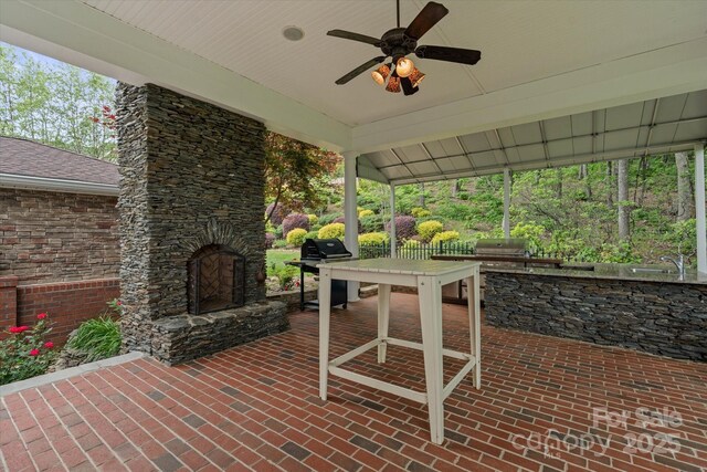 view of patio featuring exterior kitchen, a ceiling fan, a grill, and a sink