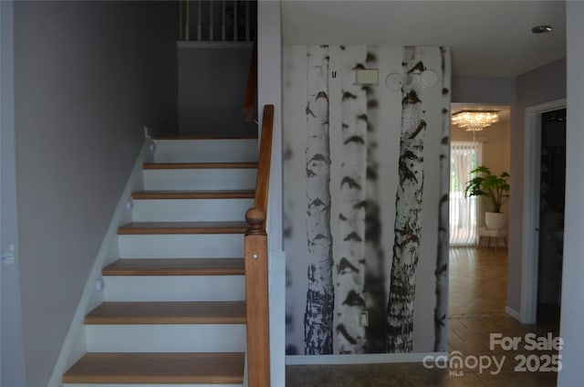stairs with a chandelier