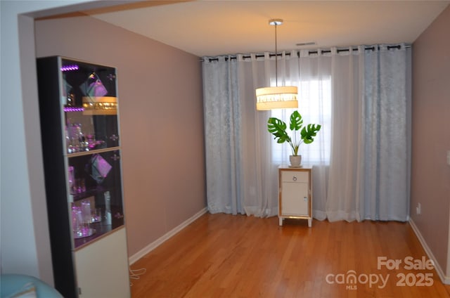 dining space featuring baseboards and wood finished floors