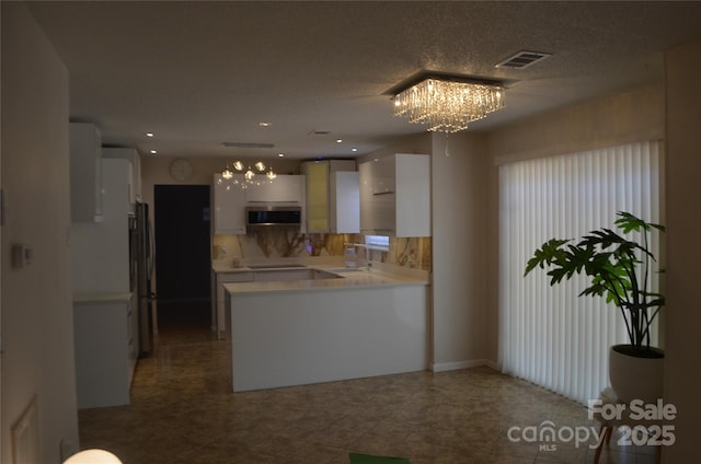 kitchen with white cabinetry, appliances with stainless steel finishes, and a chandelier