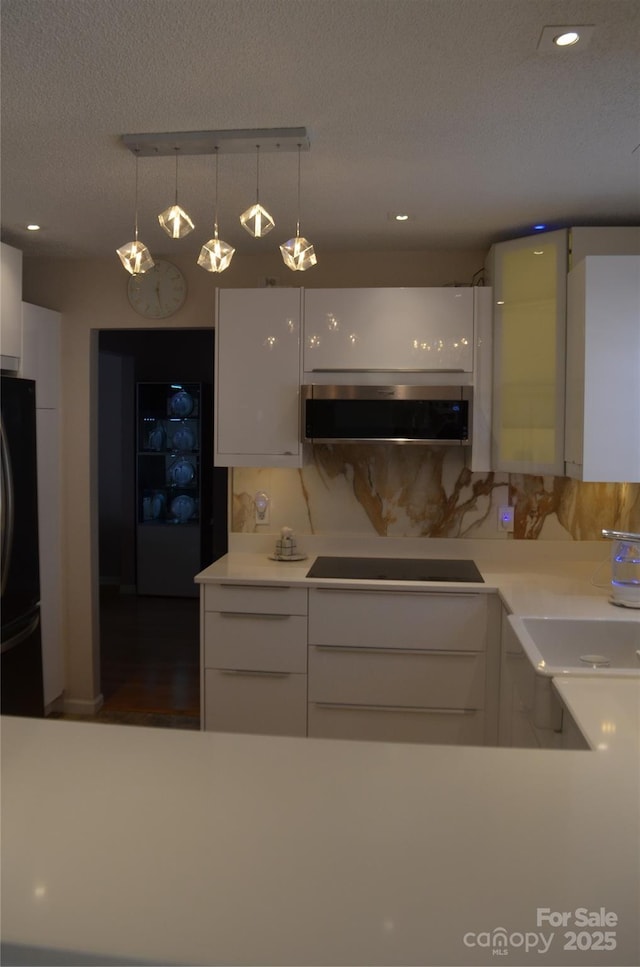 kitchen with light countertops, modern cabinets, black appliances, and white cabinets