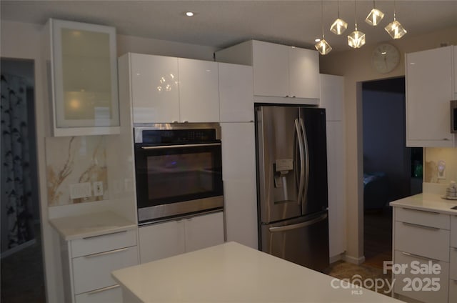 kitchen with light countertops, glass insert cabinets, stainless steel appliances, and white cabinetry