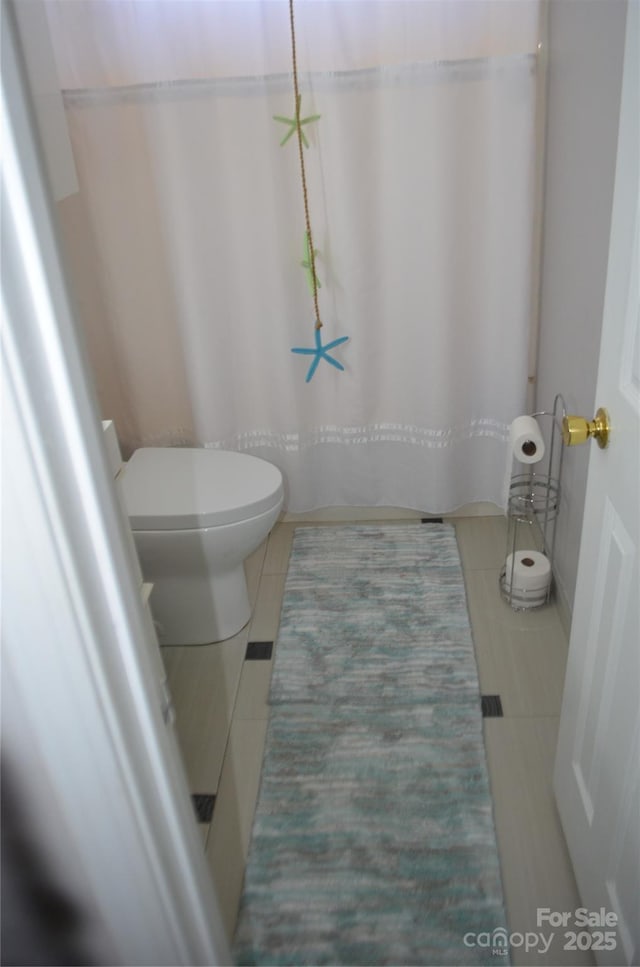 bathroom featuring tile patterned flooring and toilet