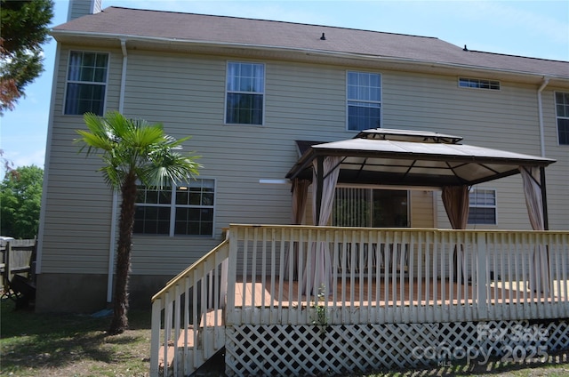 back of house featuring a deck, a gazebo, and a chimney