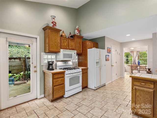 221 Holland Dr, Black Mountain, NC 28711 - kitchen with brown cabinets, white appliances, tile countertops, baseboards, and decorative backsplash