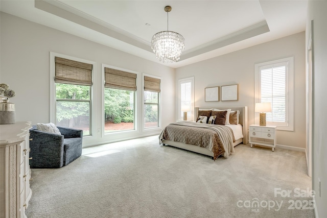 bedroom with carpet flooring, a chandelier, a raised ceiling, and ornamental molding