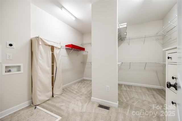 walk in closet with carpet