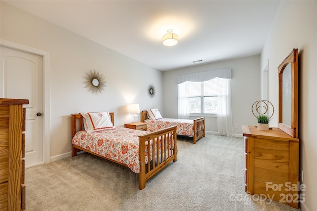 bedroom featuring light carpet and baseboards
