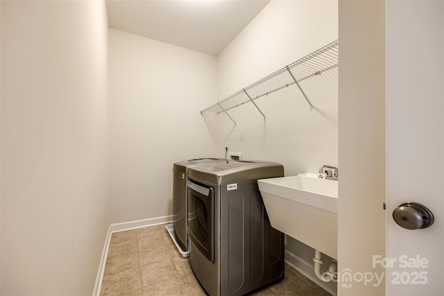 laundry area with independent washer and dryer and baseboards