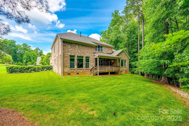 back of property featuring crawl space, brick siding, a deck, and a lawn