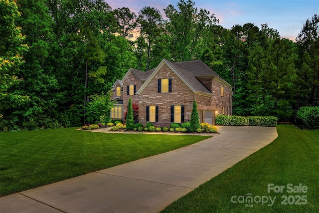 colonial house featuring brick siding, driveway, a front lawn, and roof with shingles