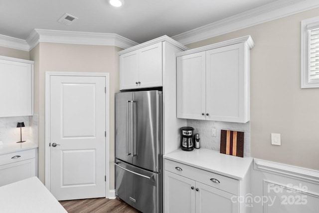 kitchen with high end refrigerator, white cabinetry, tasteful backsplash, and light countertops