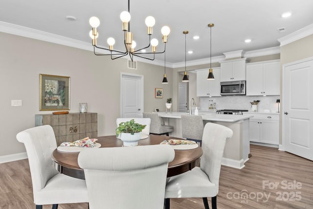 dining space with crown molding, an inviting chandelier, recessed lighting, wood finished floors, and visible vents