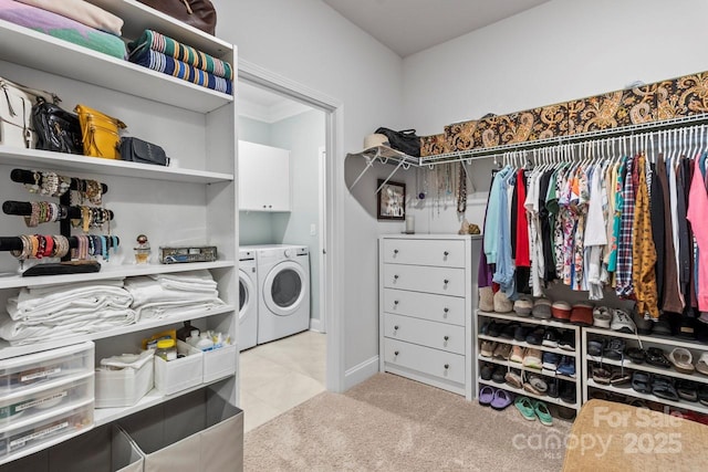 clothes washing area featuring light colored carpet, cabinet space, and washer and dryer