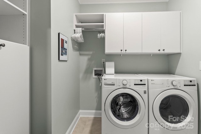 washroom featuring light tile patterned floors, baseboards, independent washer and dryer, and cabinet space