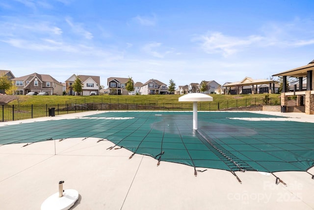 view of pool featuring a fenced in pool, a lawn, fence, and a residential view
