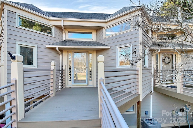 entrance to property with roof with shingles