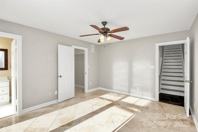 unfurnished bedroom featuring a closet, visible vents, baseboards, a walk in closet, and connected bathroom