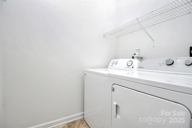 washroom with baseboards, laundry area, and washer and clothes dryer