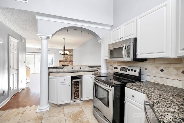 kitchen featuring appliances with stainless steel finishes, decorative backsplash, beverage cooler, and white cabinets