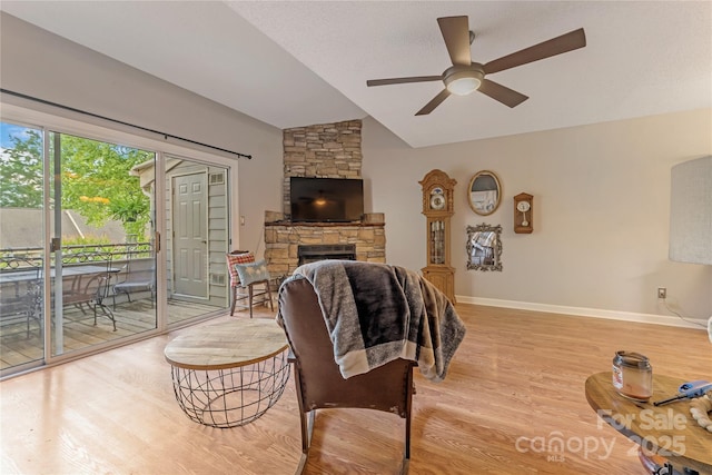 13932 Queens Harbor Rd, Charlotte, NC 28278 - living area with lofted ceiling, ceiling fan, light wood finished floors, a stone fireplace, and baseboards