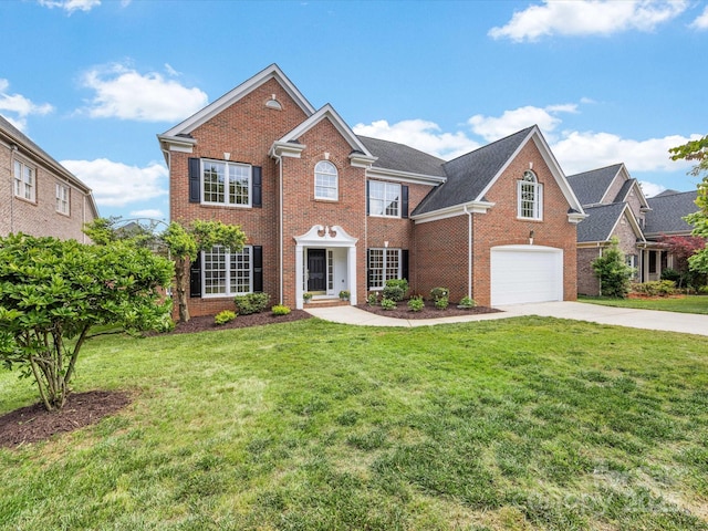 colonial house featuring brick siding, a garage, driveway, and a front yard