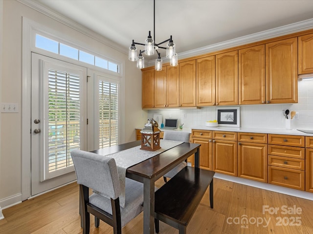 dining room featuring crown molding and light wood finished floors