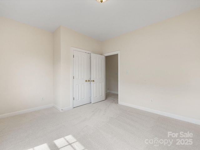 unfurnished bedroom featuring a closet, baseboards, and carpet flooring