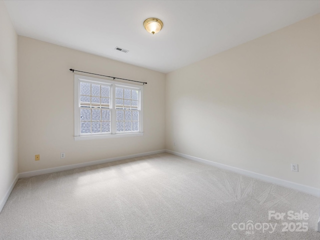 unfurnished room with baseboards, light colored carpet, and visible vents