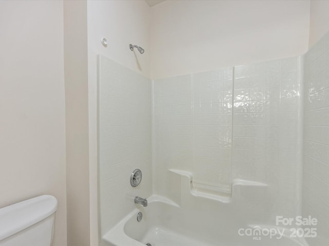 bathroom with washtub / shower combination and toilet