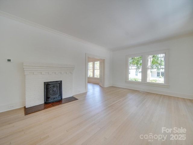 unfurnished living room with crown molding, baseboards, and wood finished floors