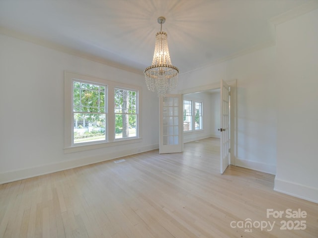 unfurnished dining area with baseboards, wood finished floors, and a notable chandelier
