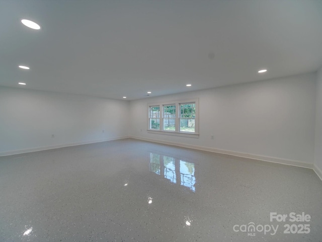 spare room featuring recessed lighting and baseboards