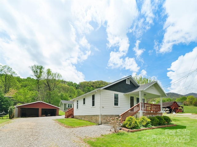 819 Mauney Cove Rd, Waynesville, NC 28786 - view of front of property featuring an outdoor structure, a garage, a front lawn, and covered porch
