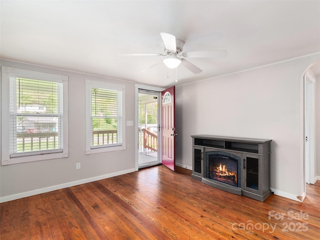 819 Mauney Cove Rd, Waynesville, NC 28786 - unfurnished living room featuring baseboards, a glass covered fireplace, wood finished floors, and ceiling fan