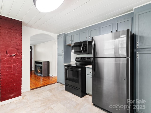 819 Mauney Cove Rd, Waynesville, NC 28786 - kitchen featuring light countertops, arched walkways, range with electric cooktop, freestanding refrigerator, and gray cabinetry