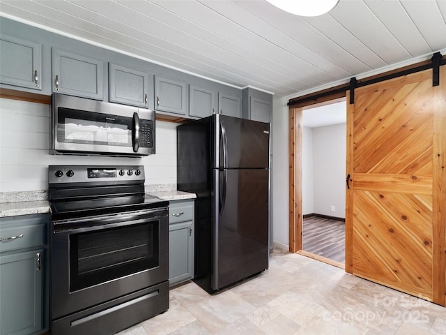 819 Mauney Cove Rd, Waynesville, NC 28786 - kitchen with gray cabinetry, light stone countertops, appliances with stainless steel finishes, and a barn door