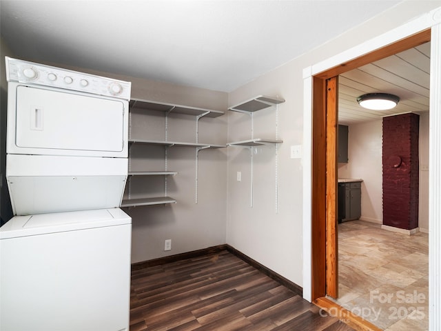 819 Mauney Cove Rd, Waynesville, NC 28786 - laundry area with dark wood-style flooring, laundry area, stacked washing maching and dryer, and baseboards