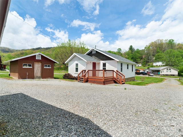 819 Mauney Cove Rd, Waynesville, NC 28786 - view of front of home featuring a deck, an outbuilding, and gravel driveway