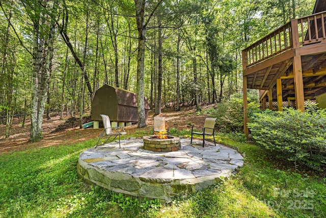 1415 Little River Campground Rd, Pisgah Forest, NC 28768 - view of yard featuring an outdoor fire pit, a deck, a patio area, and a wooded view