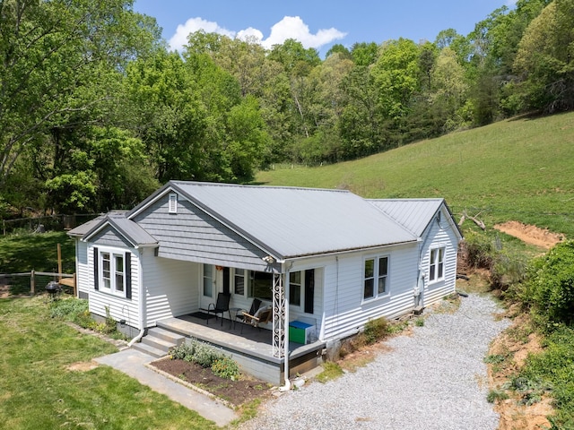 rear view of property with a lawn, a porch, metal roof, and crawl space