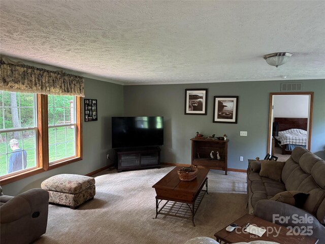 living area with baseboards, carpet flooring, a textured ceiling, and visible vents