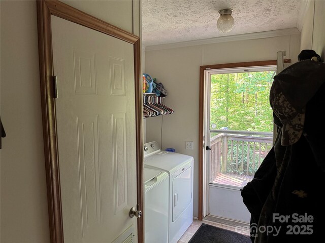 laundry area featuring laundry area, a textured ceiling, plenty of natural light, and washing machine and clothes dryer