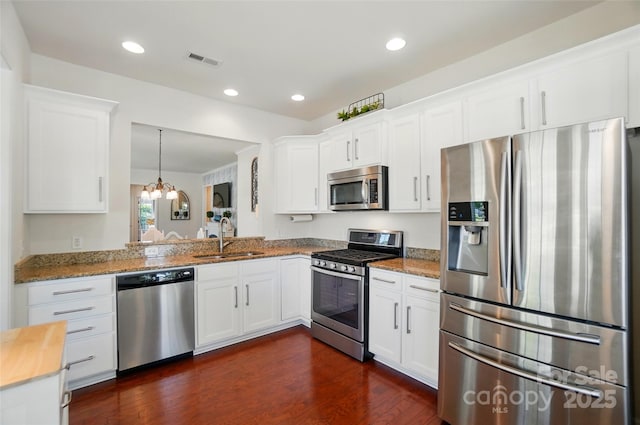 9003 Smokey Hill Ln, Fort Mill, SC 29707 - kitchen featuring stainless steel appliances, a sink, dark wood-style floors, white cabinets, and light stone counters