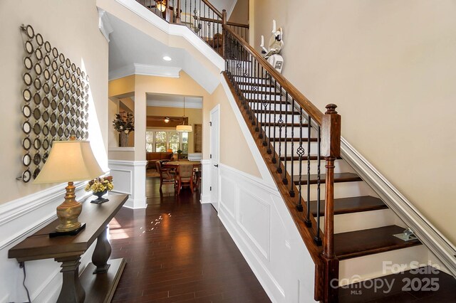 9735 Wheatfield Rd, Charlotte, NC 28277 - staircase featuring wood finished floors, a wainscoted wall, and a decorative wall