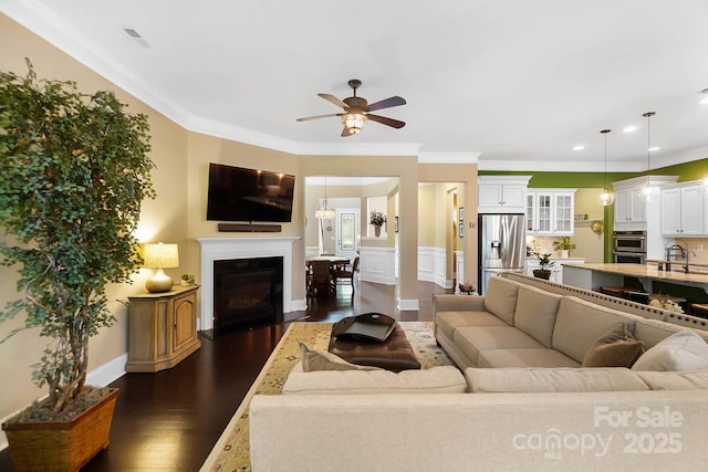 9735 Wheatfield Rd, Charlotte, NC 28277 - living room with dark wood-style flooring, ceiling fan, a glass covered fireplace, recessed lighting, and ornamental molding