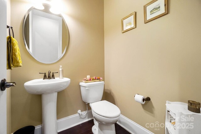 9735 Wheatfield Rd, Charlotte, NC 28277 - half bath with toilet, wood finished floors, baseboards, and a sink