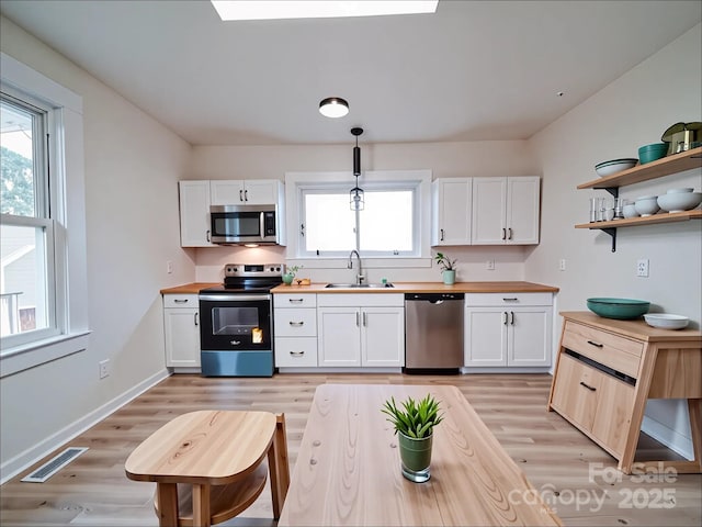 55 Ranlo Ave, Gastonia, NC 28054 - kitchen featuring visible vents, butcher block counters, light wood-style floors, a sink, and stainless steel appliances